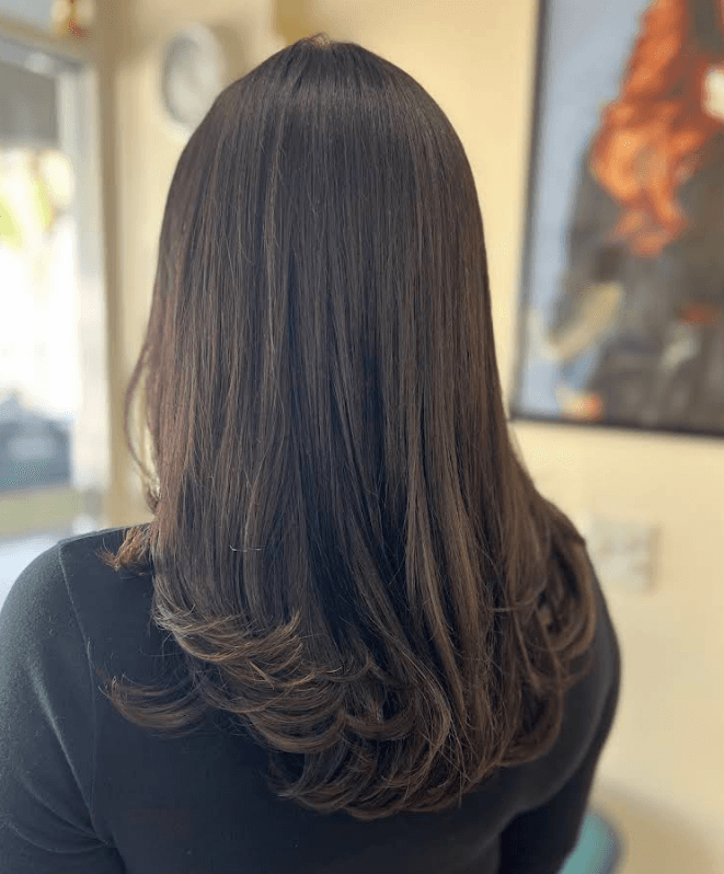 Corte con capas y blowout en cabello castaño oscuro